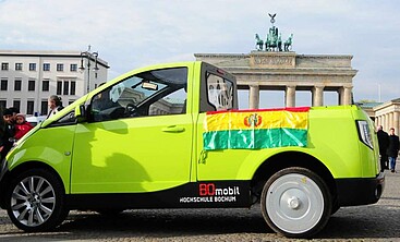 BOmobil mit bolivianischer Flagge vor dem Brandenburger Tor